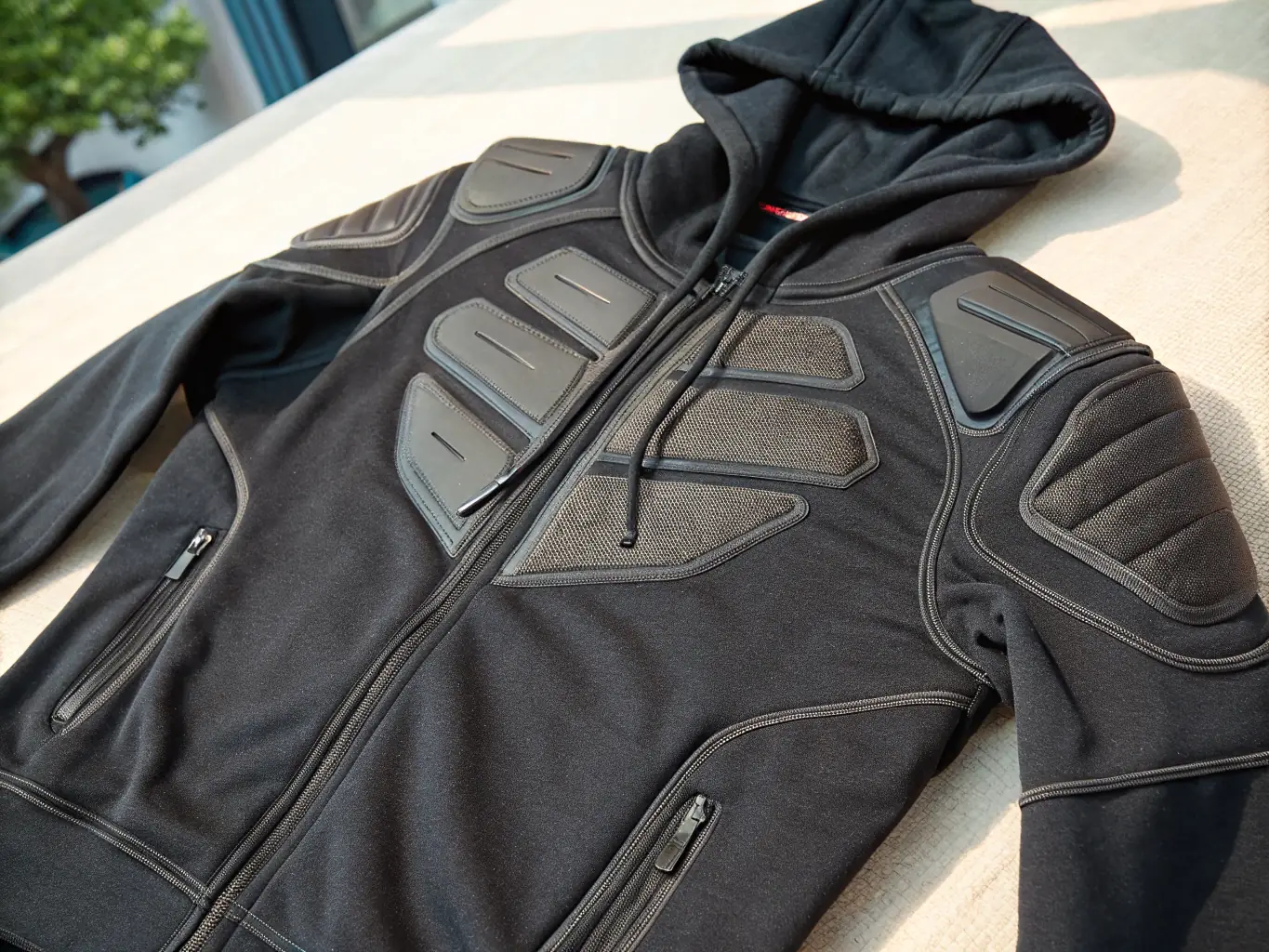 A close-up of a waterproof textile motorcycle jacket, showcasing the sealed zippers and breathable membrane.